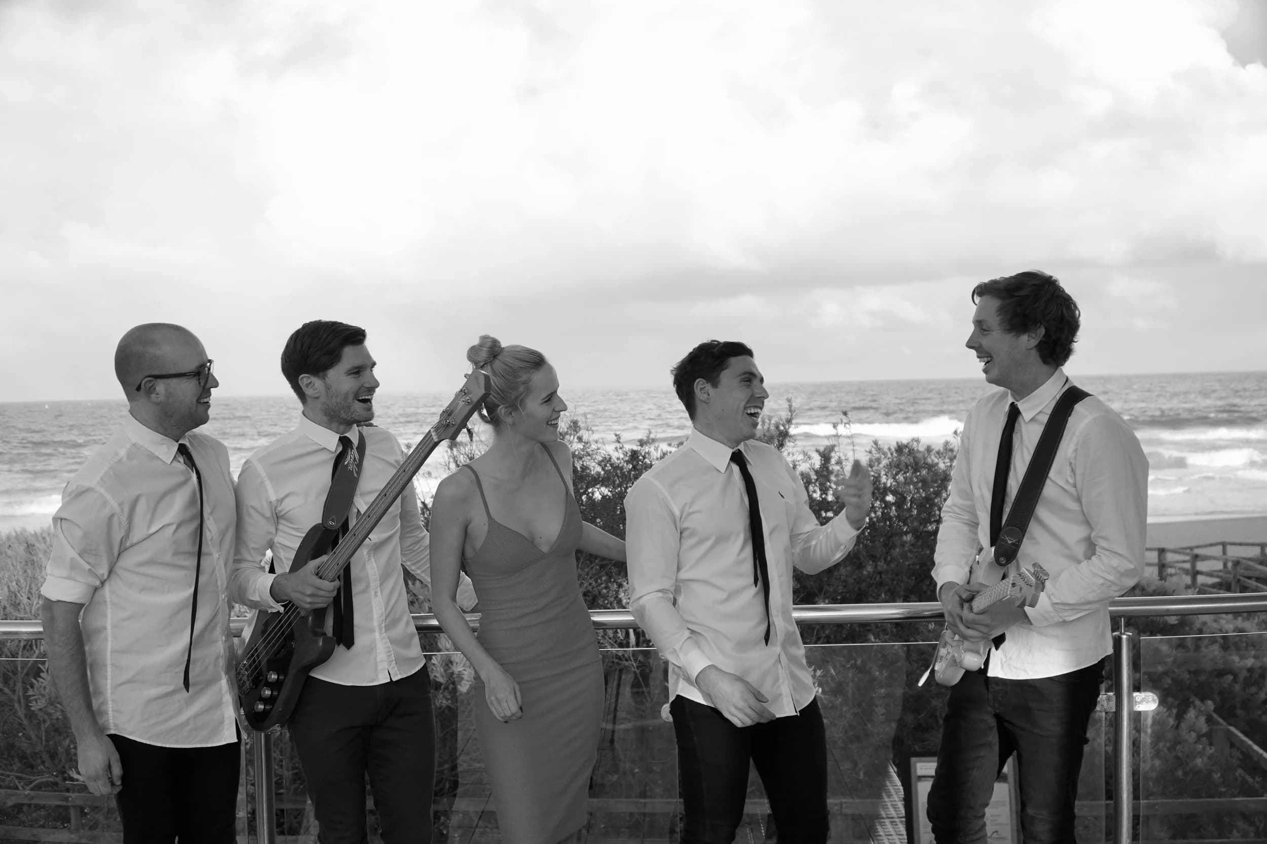Blue Vinyl 5-piece cover band laughing together at a coastal venue, Central Coast NSW